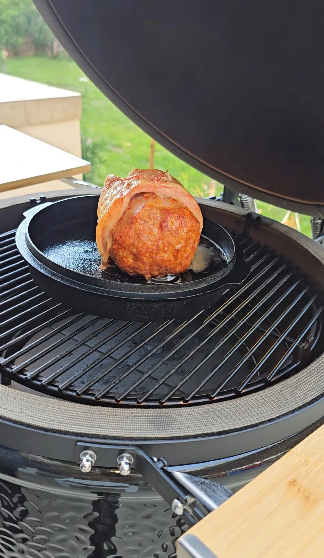 Baconbe tekert sült öntöttvas serpenyőben a grillen