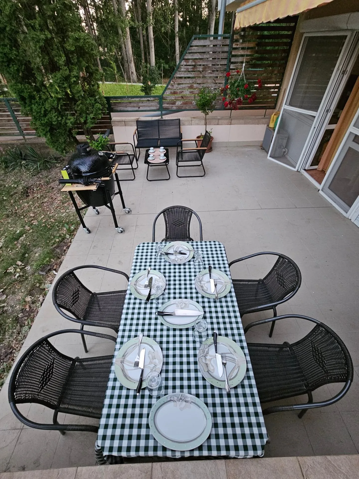 Megterített teraszos étkező kamado grillel és pihenősarokkal