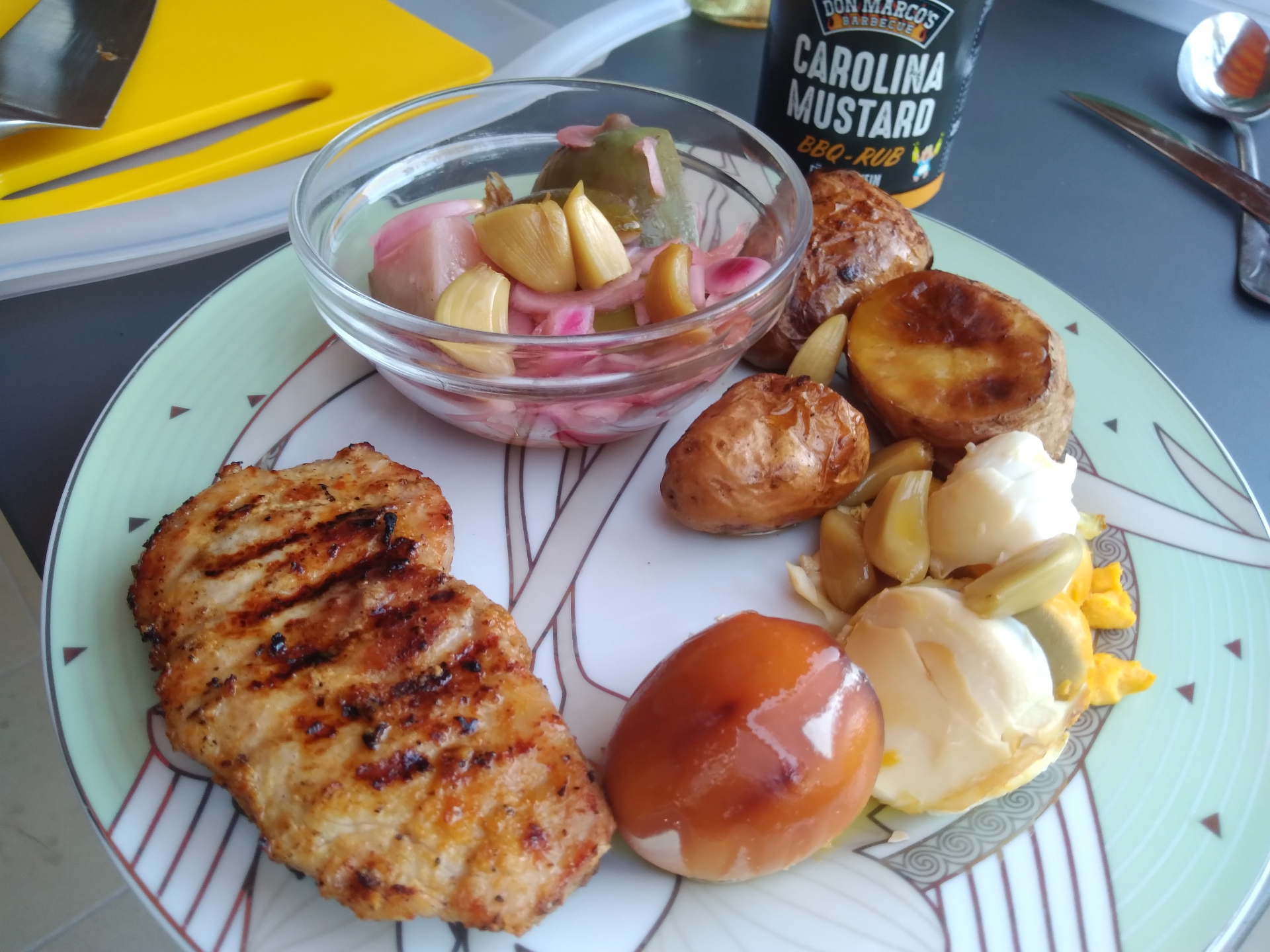Tálalt grilltányér grillezett tarjával, sült újkrumplival és savanyúsággal a teraszi vacsorán