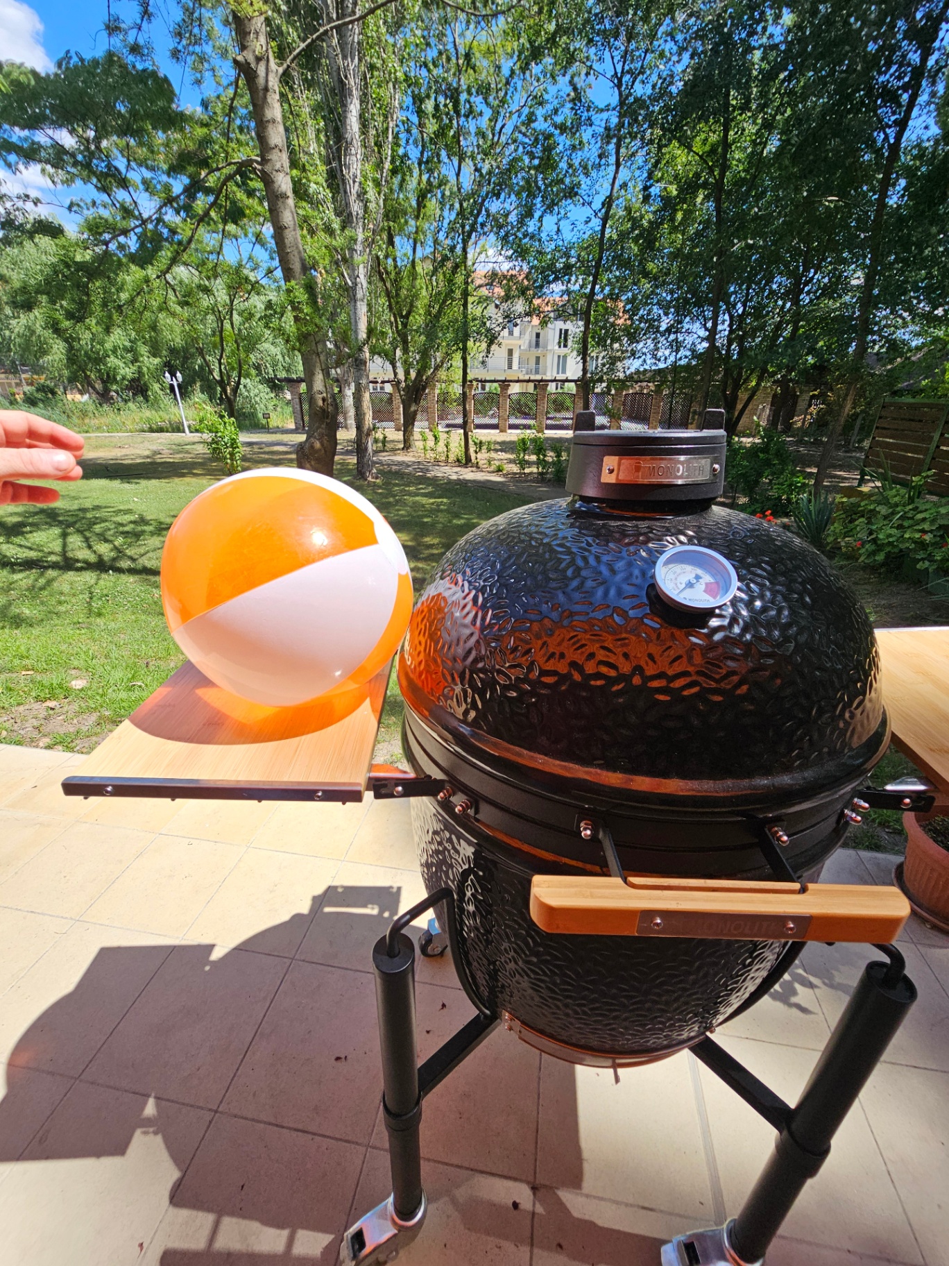 Monolith kamado grill közelről, hőmérővel és nyári hangulatú strandlabdával