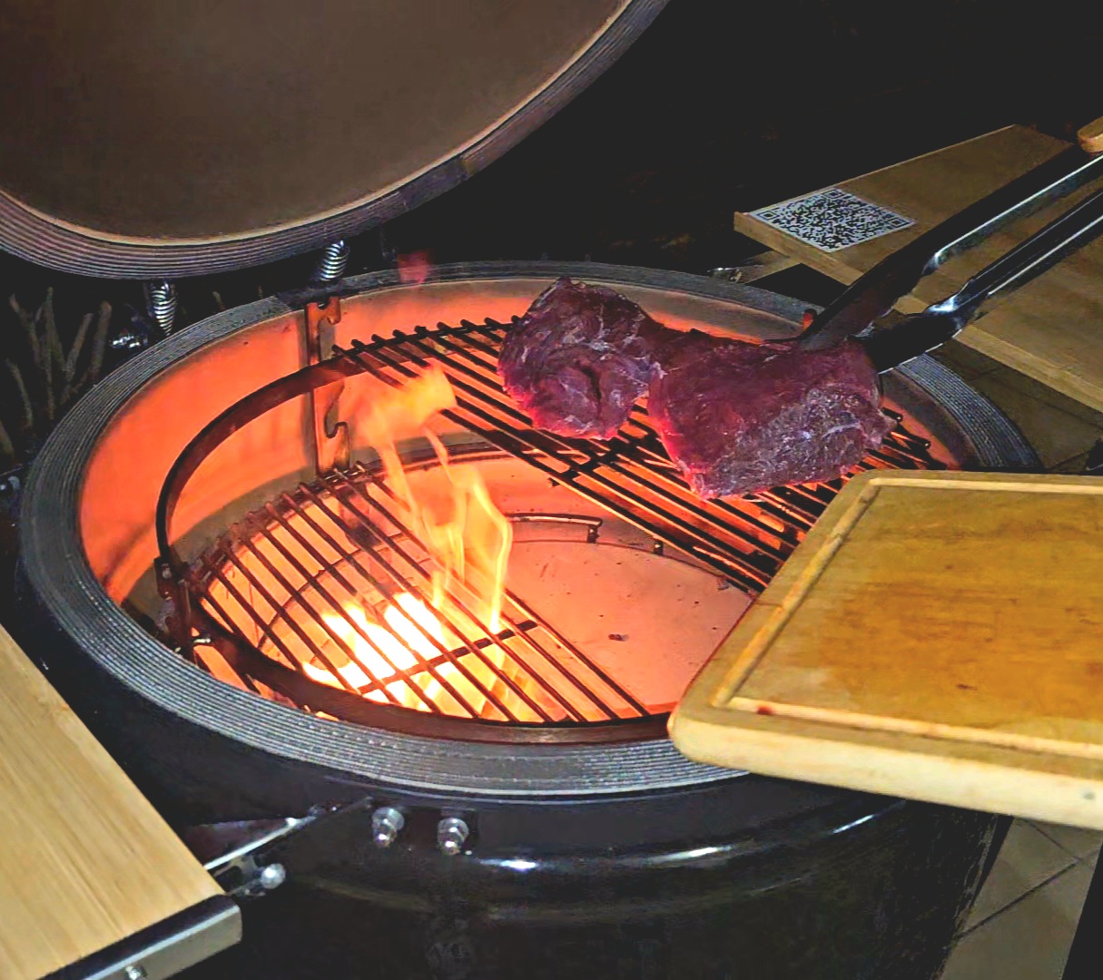 Steak lángok felett a nyitott kamado grillben