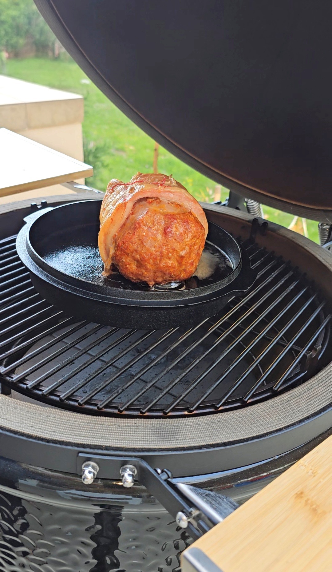 Baconbe tekert sült öntöttvas serpenyőben a grillen