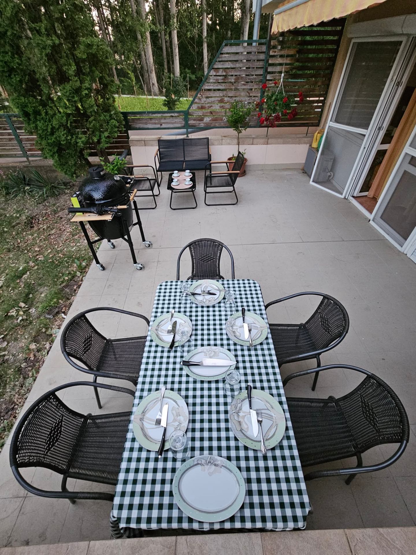 Megterített teraszas étkező kamado grillel és pihenősarokkal