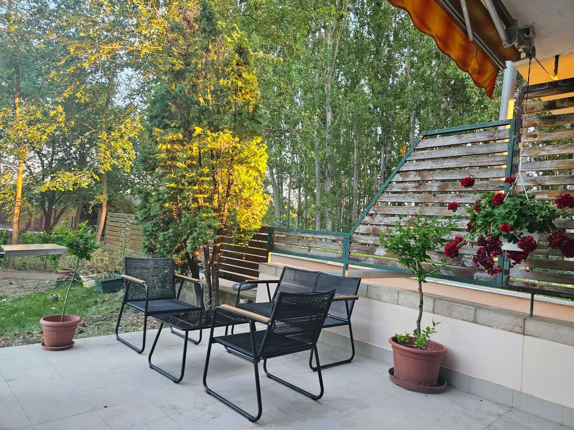 Terasz fekete lounge bútorokkal az esti napfényben